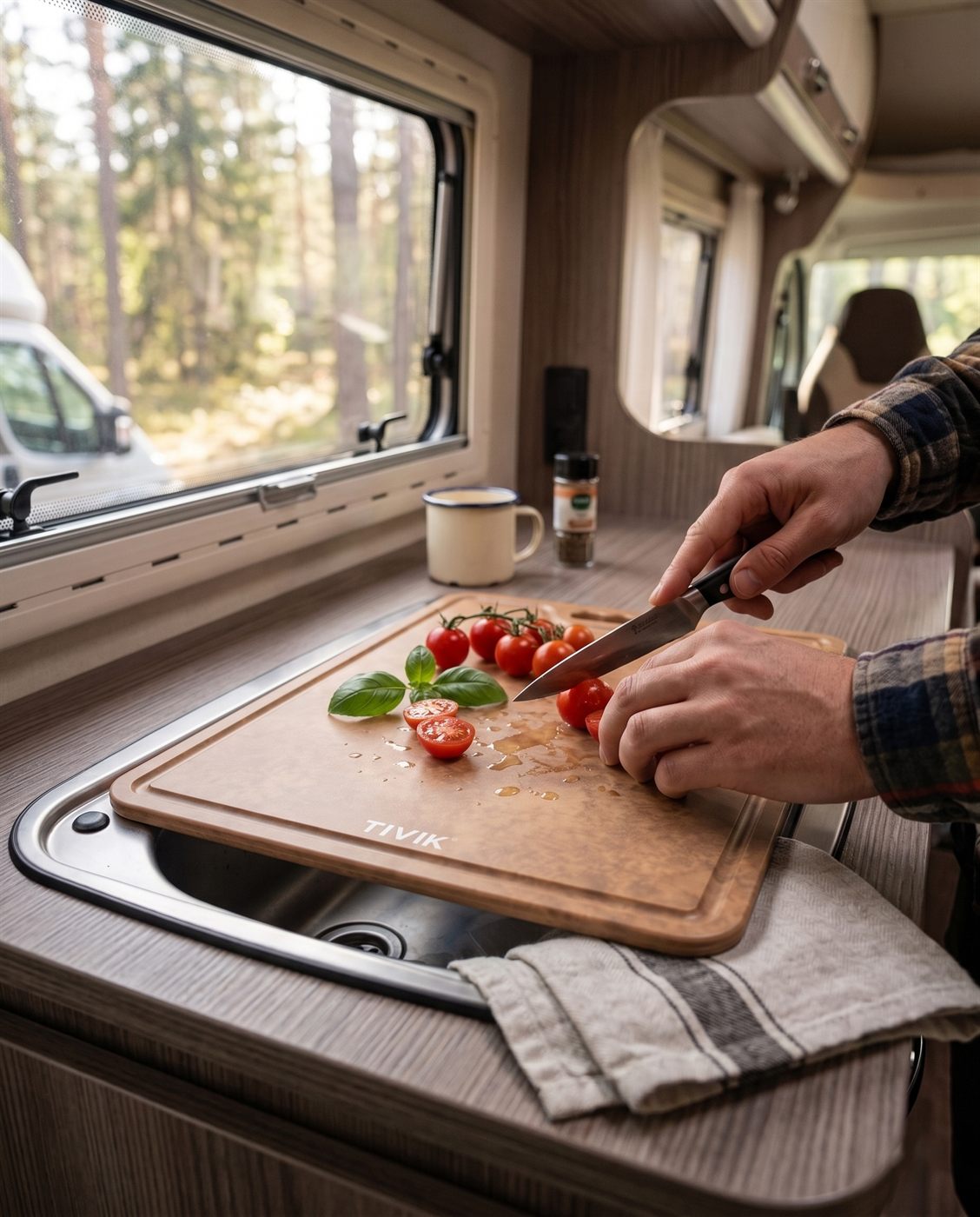 Tomaatjes snijden op een lichtbruine TIVIK-plank in een camper